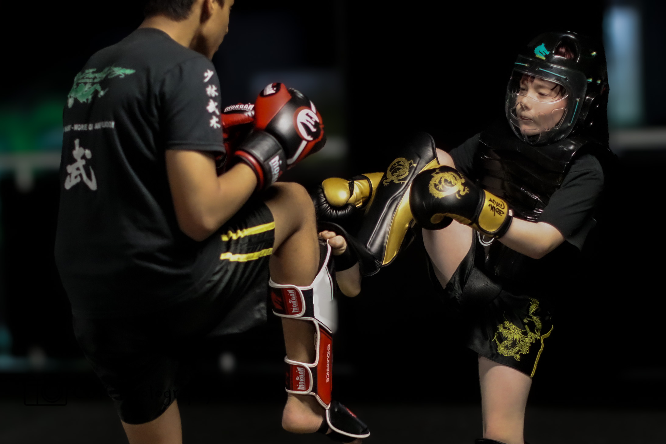 Kids practicing MMA with protective gear in a safe environment at Emerald Dragon Martial Arts.
