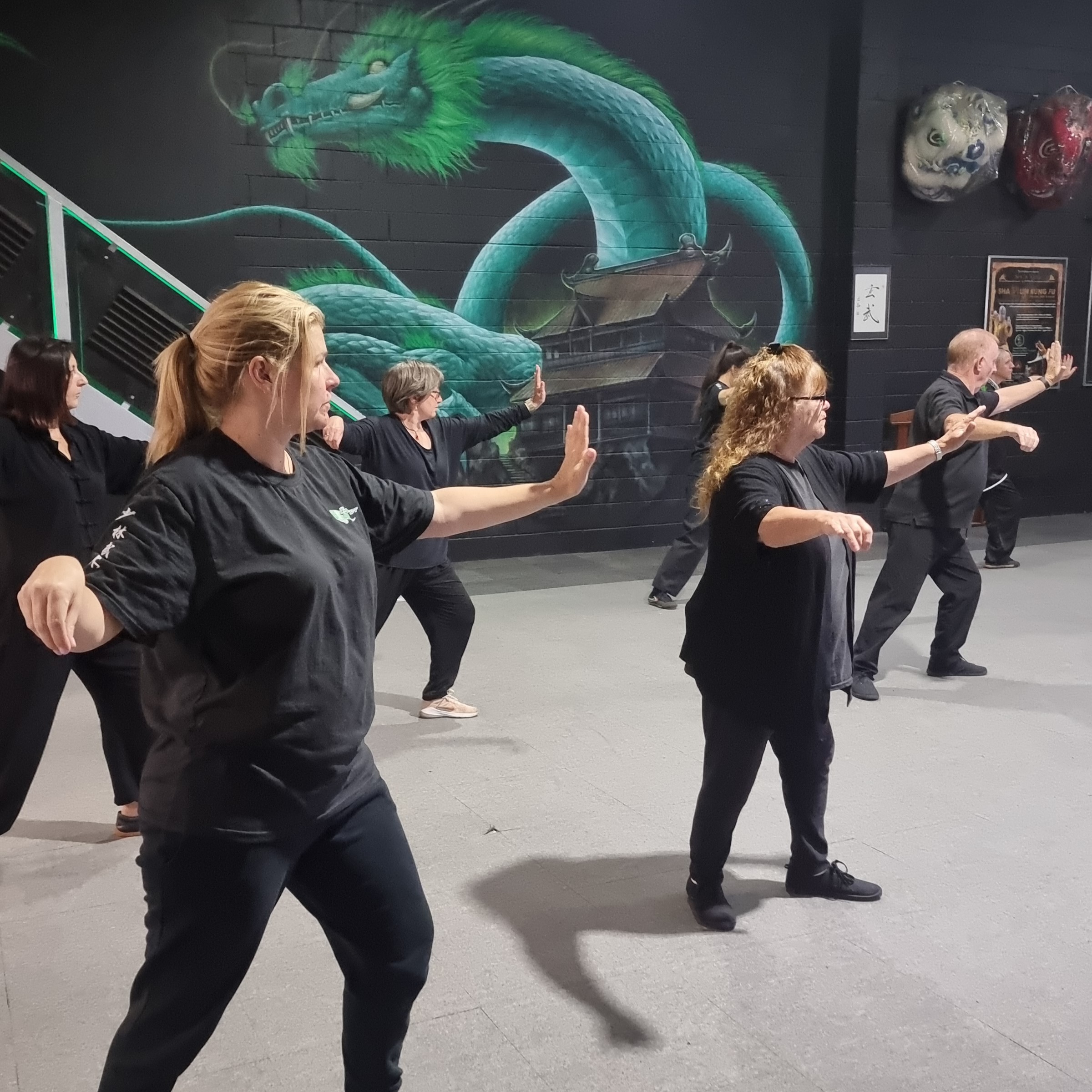 Tai Chi class at Emerald Dragon Martial Arts with participants practicing flowing movements.